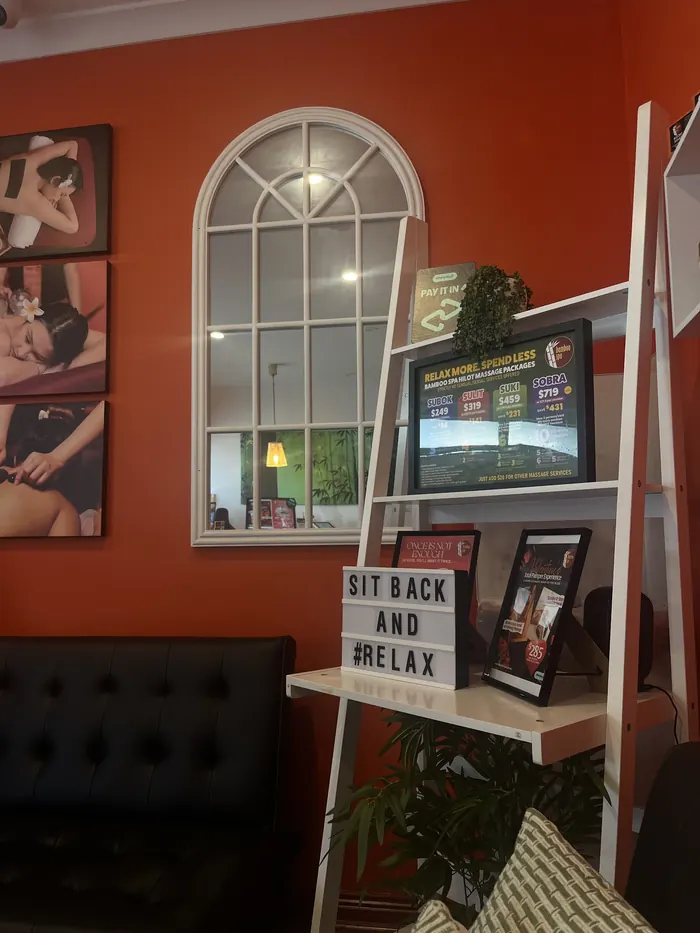 A lounge corner with an arched window and a Sit back and relax letter board