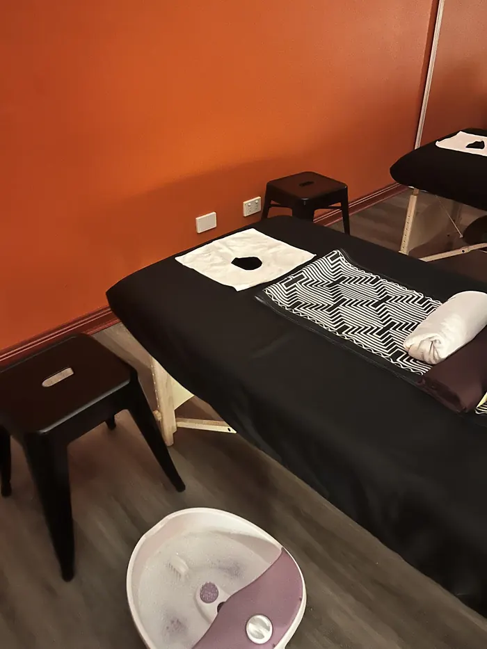 A treatment bed with a foot-wash basin ready beside it