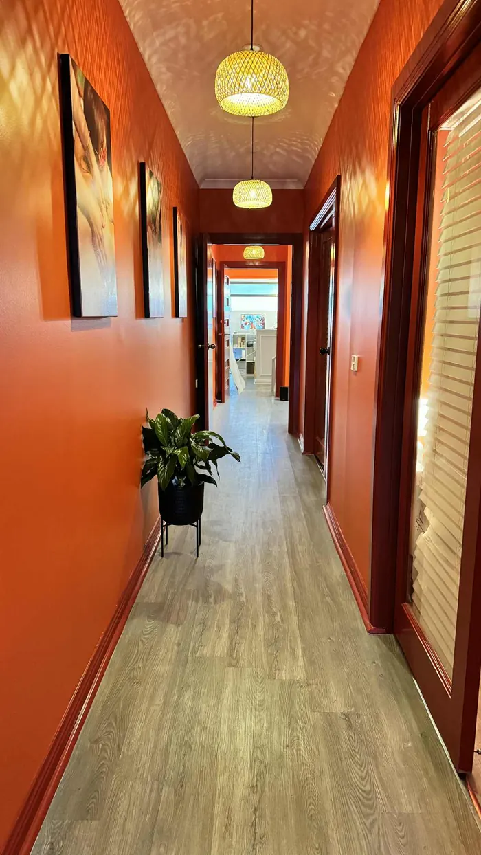 The warm orange hallway lit by woven bamboo pendant lights