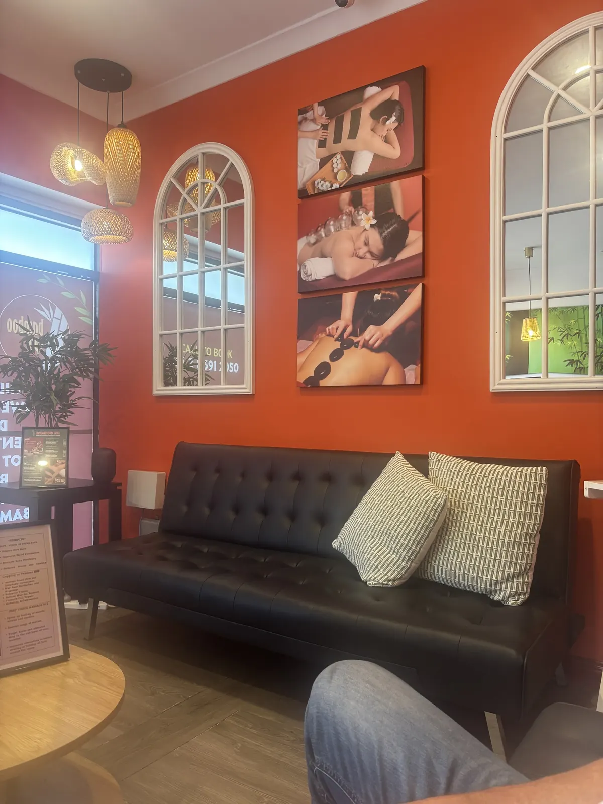 The Bamboo Spa lounge: burnt-orange walls, white arched windows and a black leather sofa